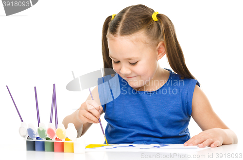 Image of Little girl is drawing using pencils
