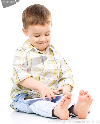 Image of Young boy is using tablet