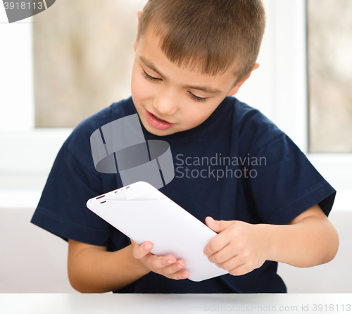 Image of Young boy is using tablet