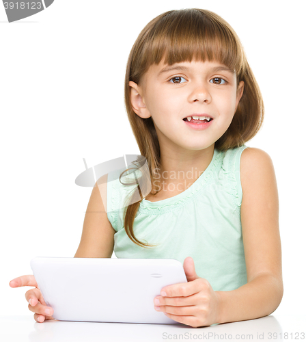 Image of Young cheerful girl is using tablet