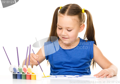 Image of Little girl is painting with gouache