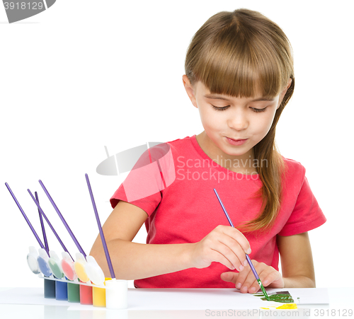 Image of Little girl is painting with gouache