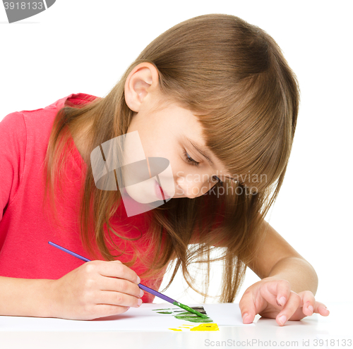 Image of Little girl is painting with gouache