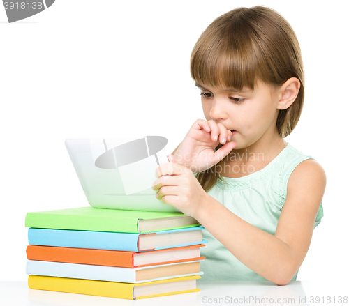 Image of Young girl is using tablet while studying