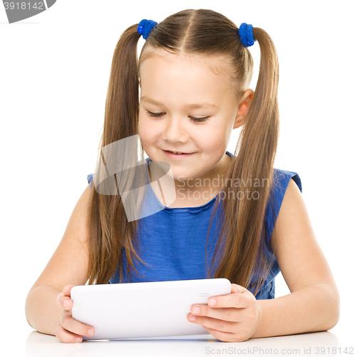 Image of Young cheerful girl is using tablet