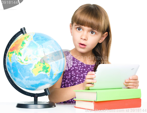 Image of Young girl is using tablet while studying