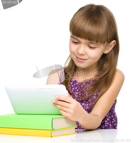 Image of Young cheerful girl is using tablet