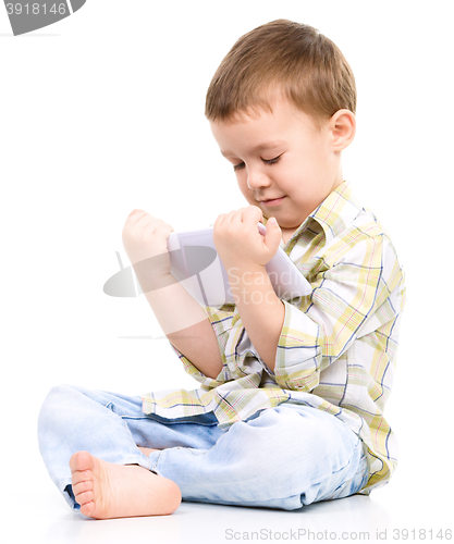Image of Young boy is using tablet