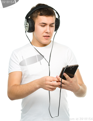 Image of Young man enjoying music using headphones