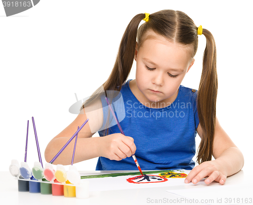 Image of Little girl is painting with gouache