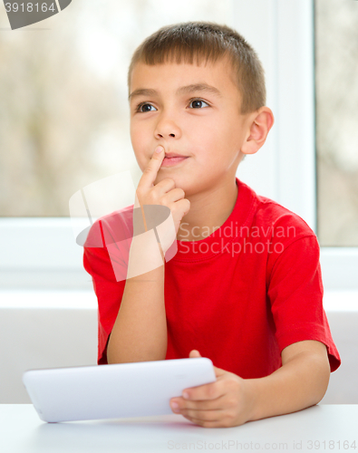 Image of Young boy is using tablet