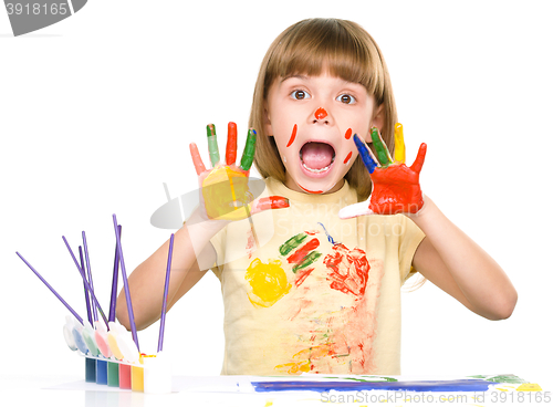 Image of Portrait of a cute girl playing with paints