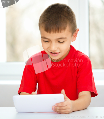 Image of Young boy is using tablet
