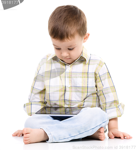 Image of Young boy is using tablet