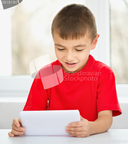 Image of Young boy is using tablet