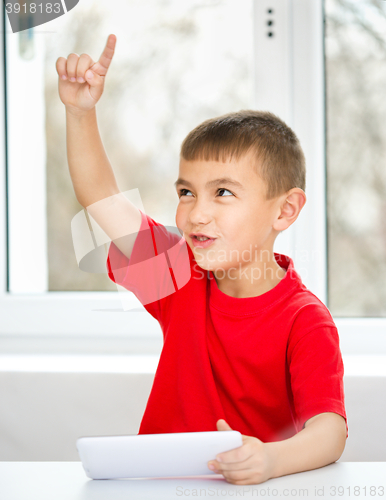 Image of Young boy is using tablet