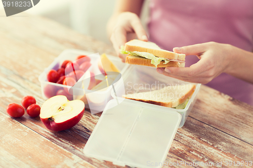 Image of close up of woman with food in plastic container