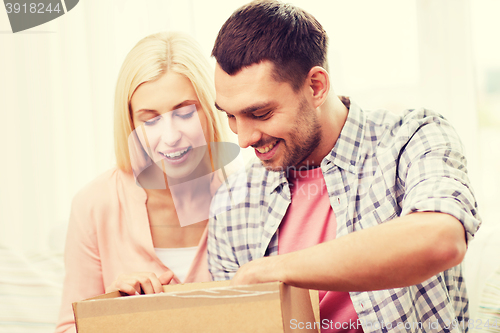 Image of happy couple with parcel box at home