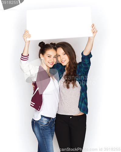 Image of smiling teenage girls holding white blank board