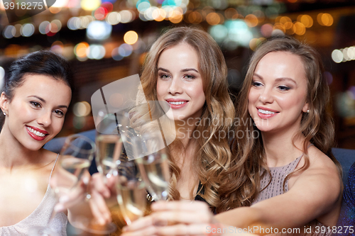 Image of happy women with champagne glasses at night club