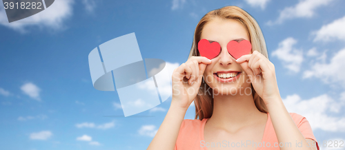 Image of happy young woman with red heart shapes on eyes