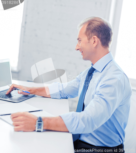 Image of smiling businessman working in office