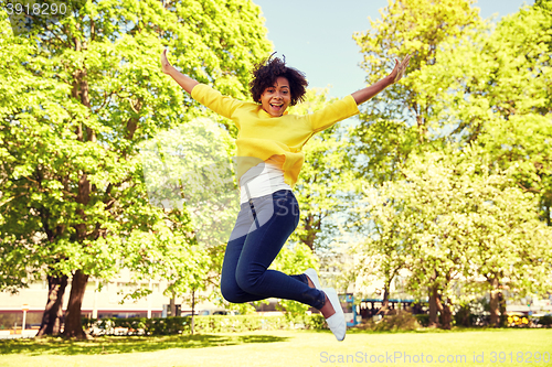 Image of happy african american young woman in summer park