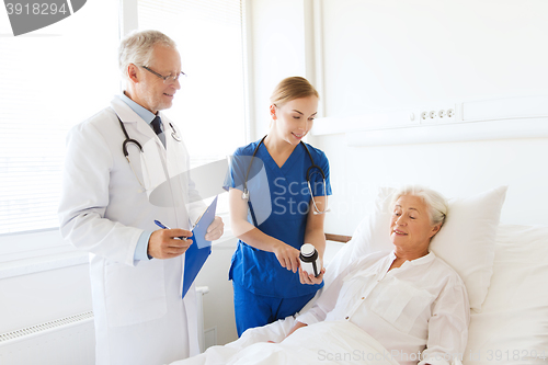 Image of doctor giving medicine to senior woman at hospital