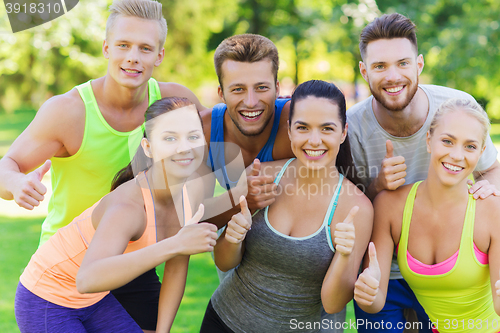 Image of group of happy sporty friends showing thumbs up