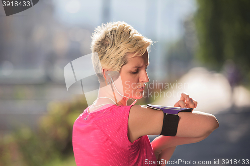 Image of jogging woman setting phone before jogging