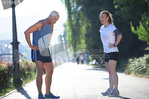 Image of jogging couple planning running route  and setting music