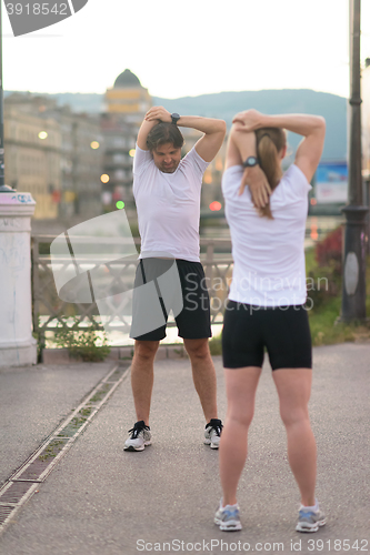 Image of couple warming up before jogging