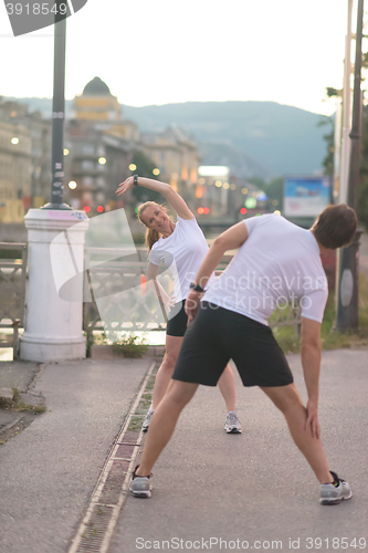 Image of couple warming up before jogging