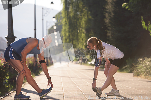 Image of couple warming up and stretching before jogging