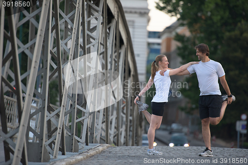 Image of couple warming up and stretching before jogging