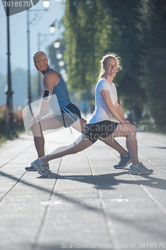 Image of couple warming up and stretching before jogging