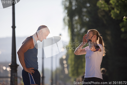 Image of jogging couple planning running route  and setting music