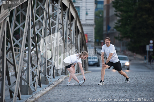 Image of couple warming up and stretching before jogging