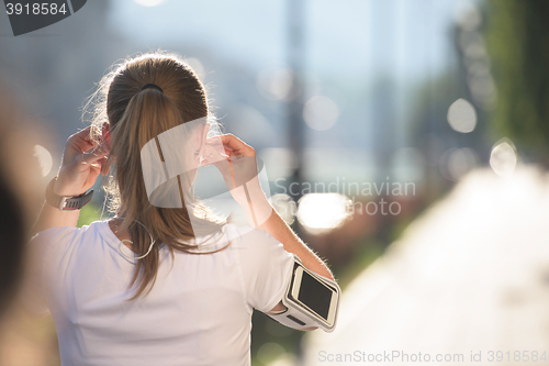 Image of jogging woman setting phone before jogging