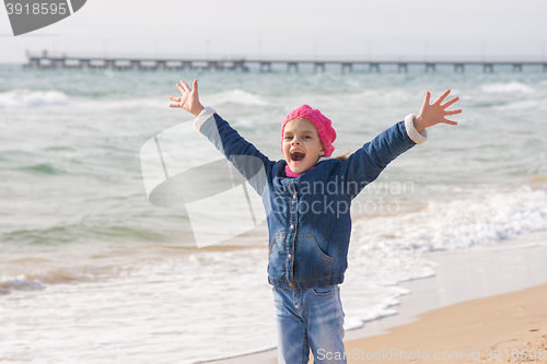 Image of Seven-year girl rejoices arrival of the sea on the coast in the spring