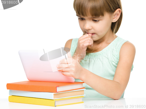 Image of Young girl is using tablet while studying