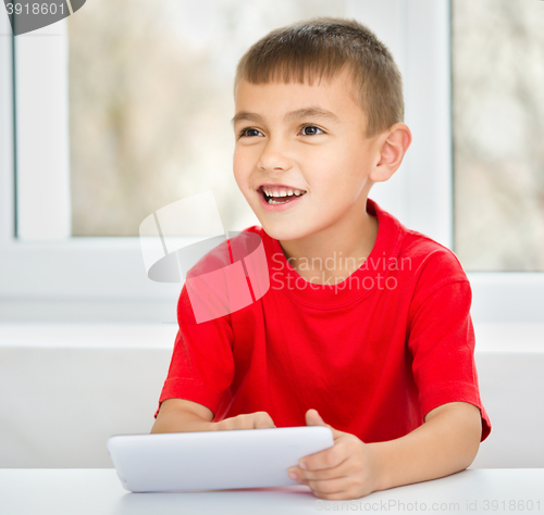 Image of Young boy is using tablet