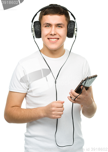 Image of Young man enjoying music using headphones