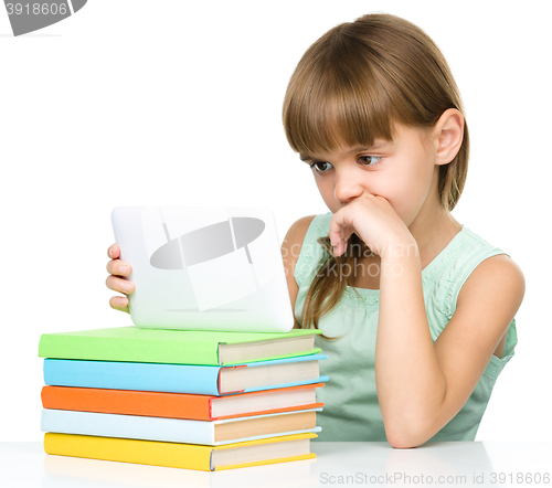 Image of Young girl is using tablet while studying
