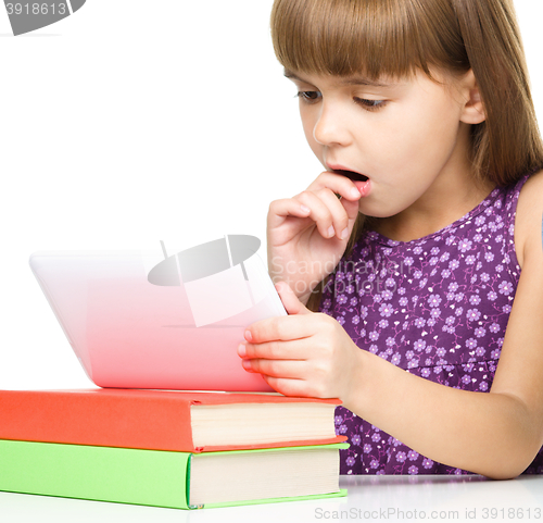 Image of Young girl is using tablet while studying