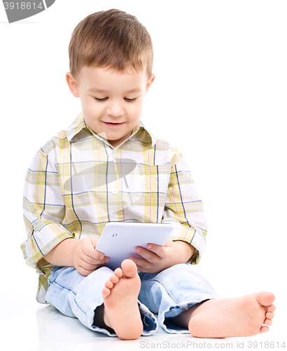 Image of Young boy is using tablet