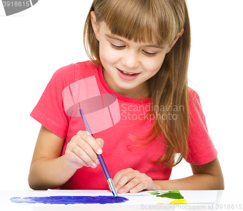 Image of Little girl is painting with gouache