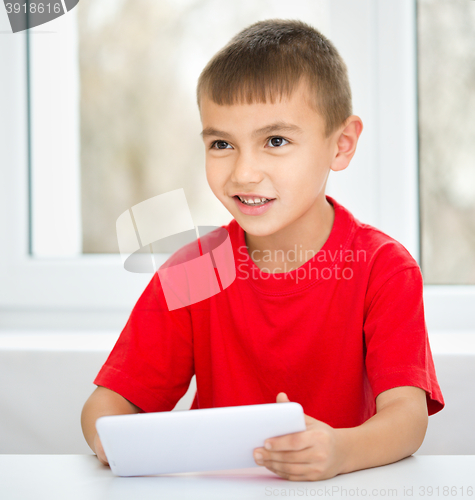 Image of Young boy is using tablet