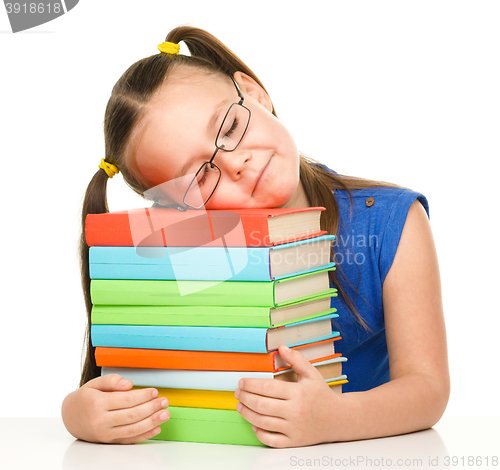Image of Little girl is sleeping on her books
