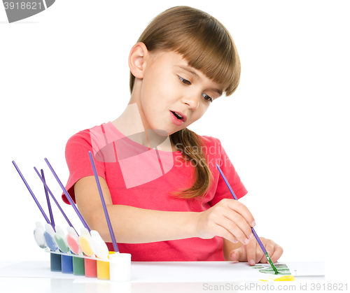 Image of Little girl is painting with gouache